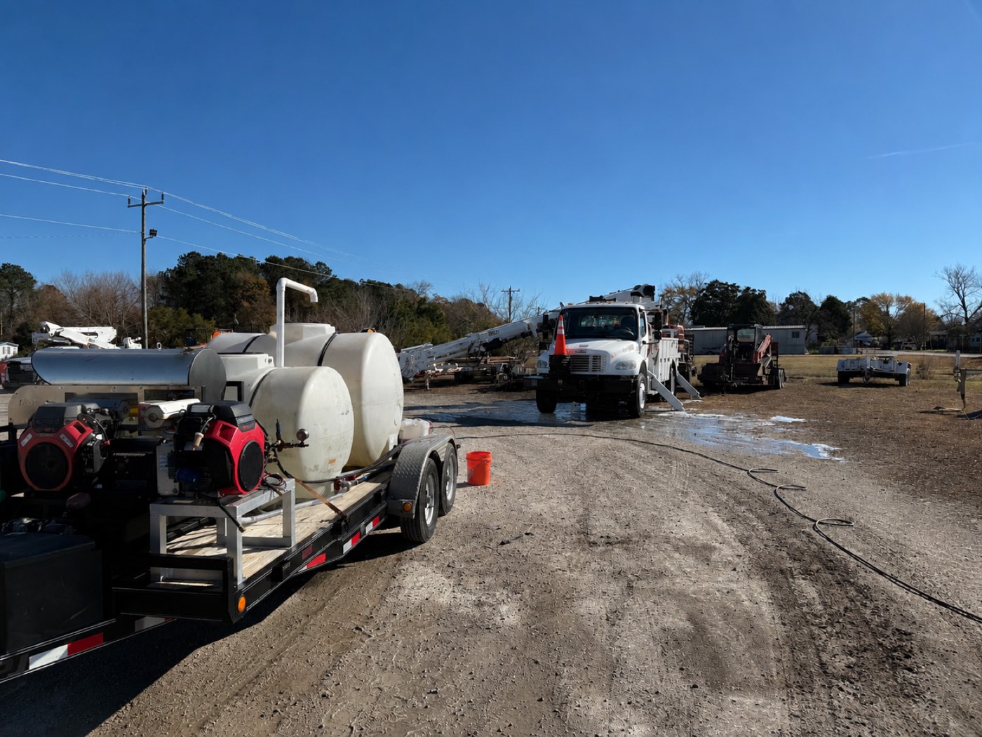 Water trailer + bucket trucks — mid-spray